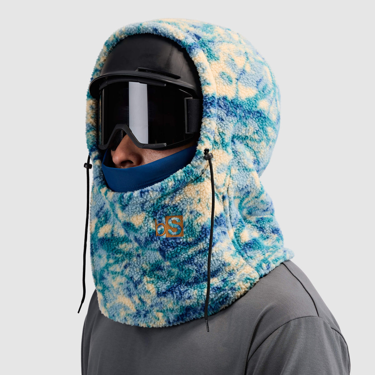 BlackStrap Caldera Hood Sherpa Fleece Overhood Pulse Deschutes worn by a man wearing a helmet and ski goggles #color_pulse deschutes