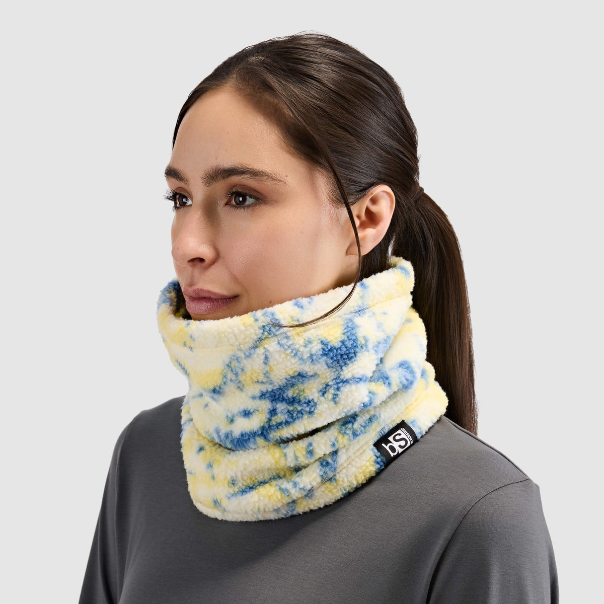 BlackStrap Caldera Sherpa Fleece Tube Neck Gaiter Pulse Orion worn by a woman around the neck like a scarf #color_pulse orion