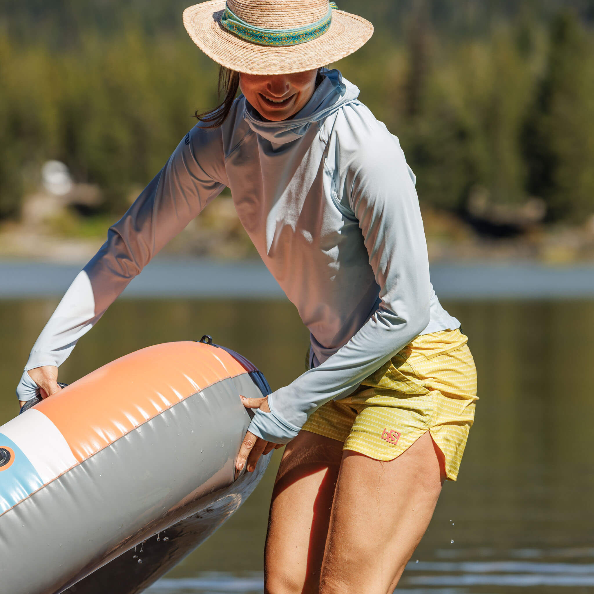 Women at the lake with an innertube floaty wearing the BlackStrap Evap Short with a Brackish Sun Hoodie