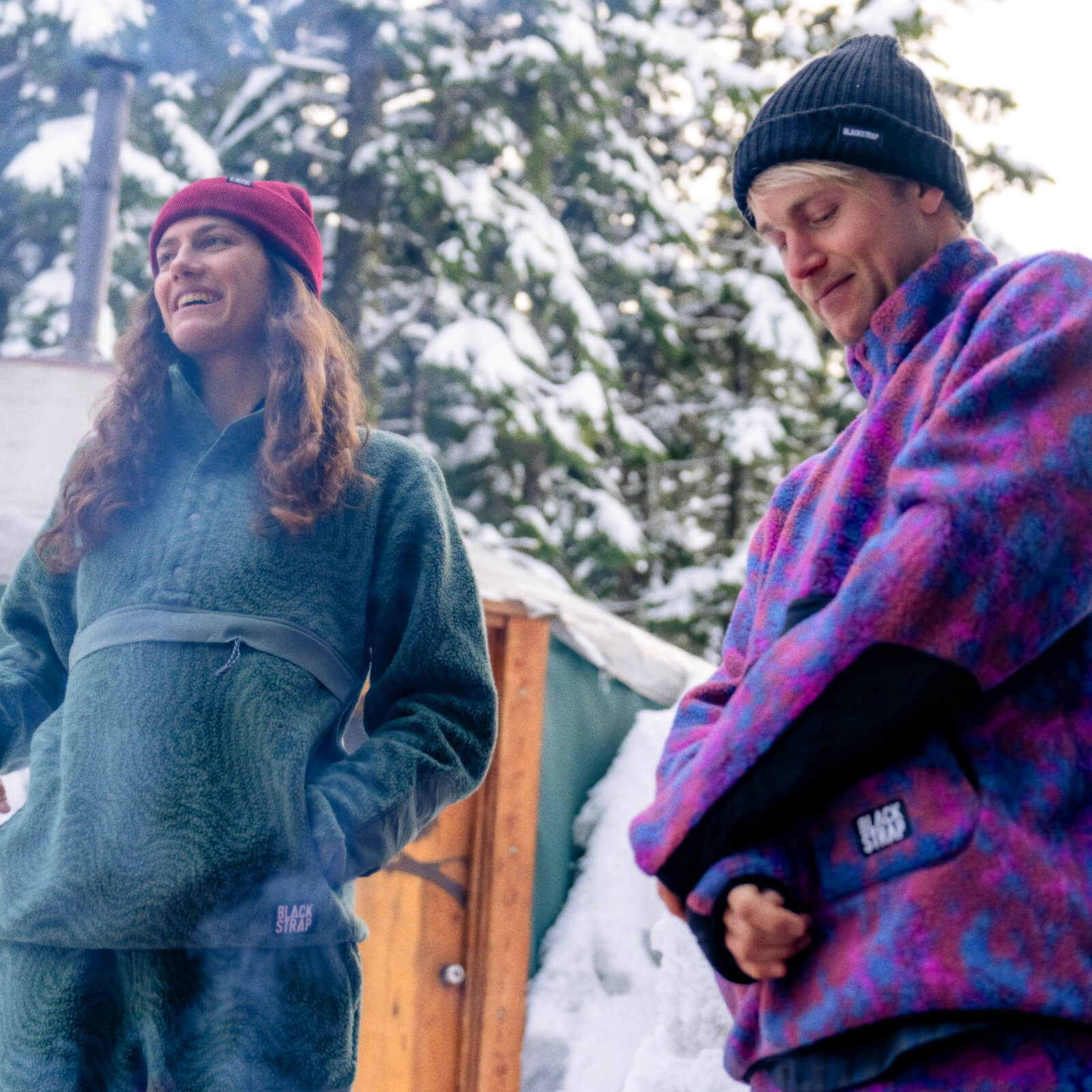 Caldera Mid Layer set being showased by man and woman by a fire