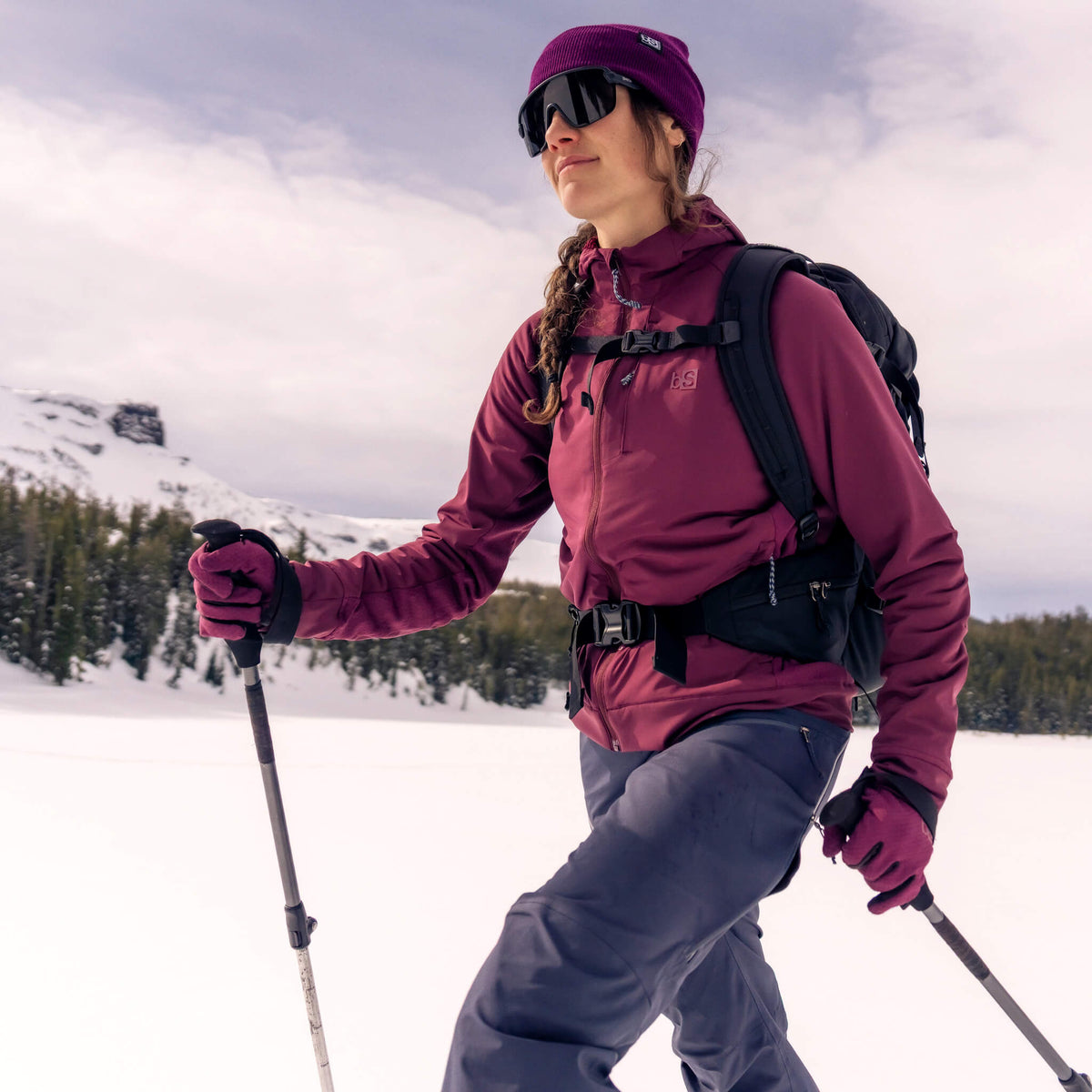 Women wearing the BlackStrap Tribrid hooded jacket backcountry skiing
