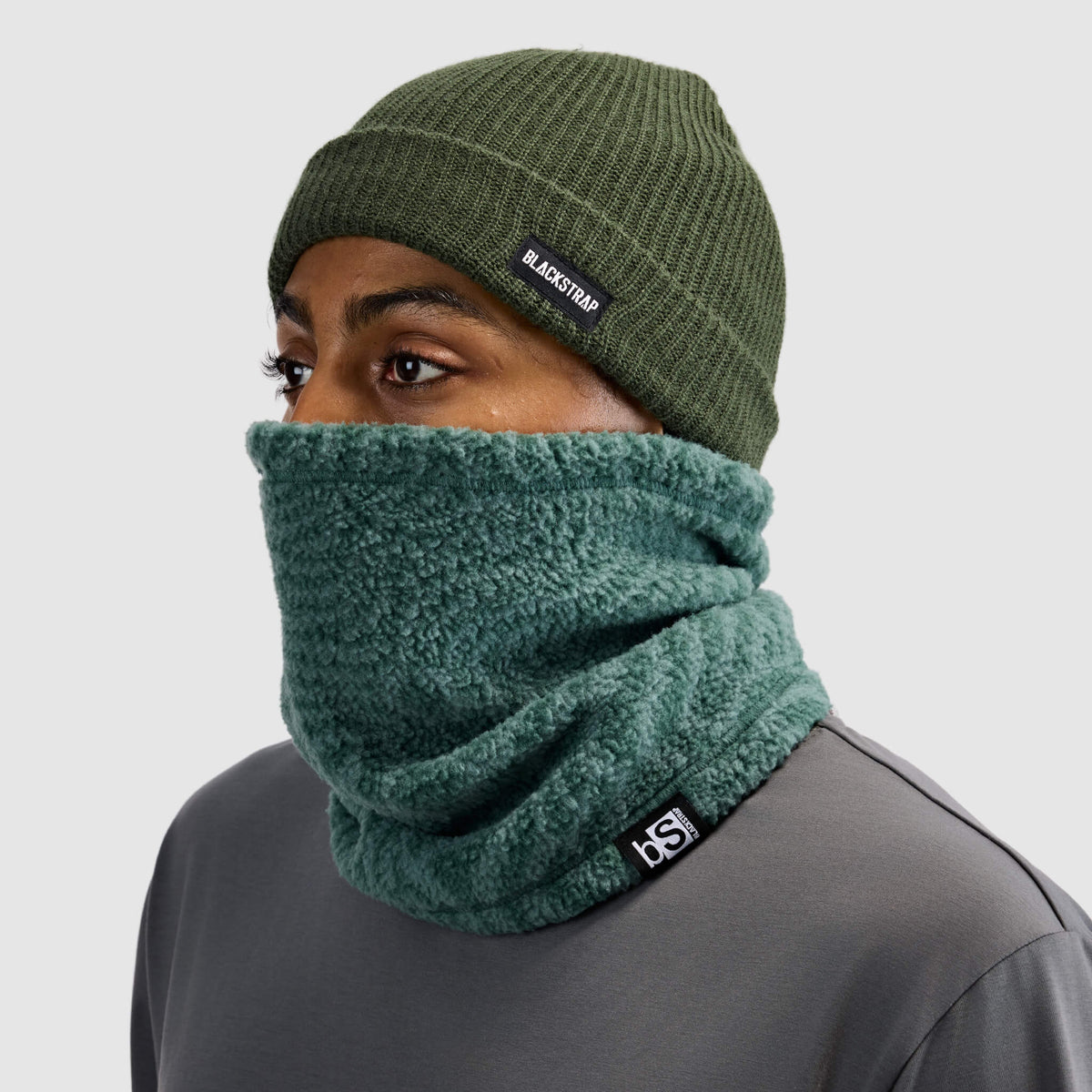 BlackStrap Caldera Sherpa Fleece Tube Neck Gaiter Inprint Obsidian worn by a man with a beanie #color_inprint obsidian