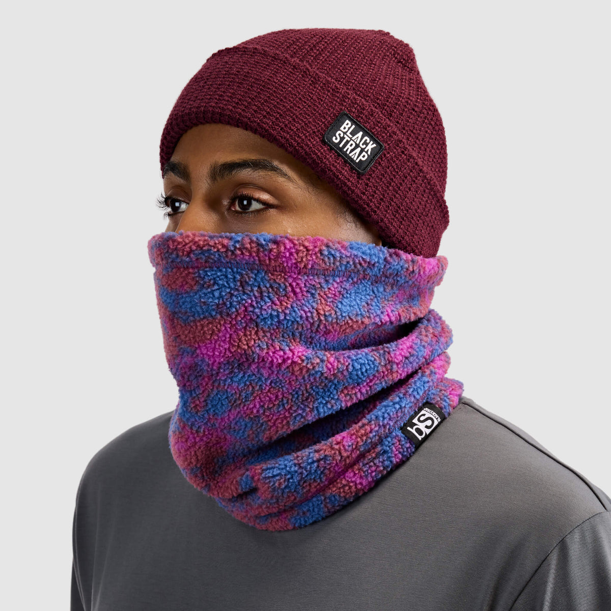 BlackStrap Caldera Sherpa Fleece Tube Neck Gaiter Pulse Currant worn by a man with a beanie #color_pulse currant