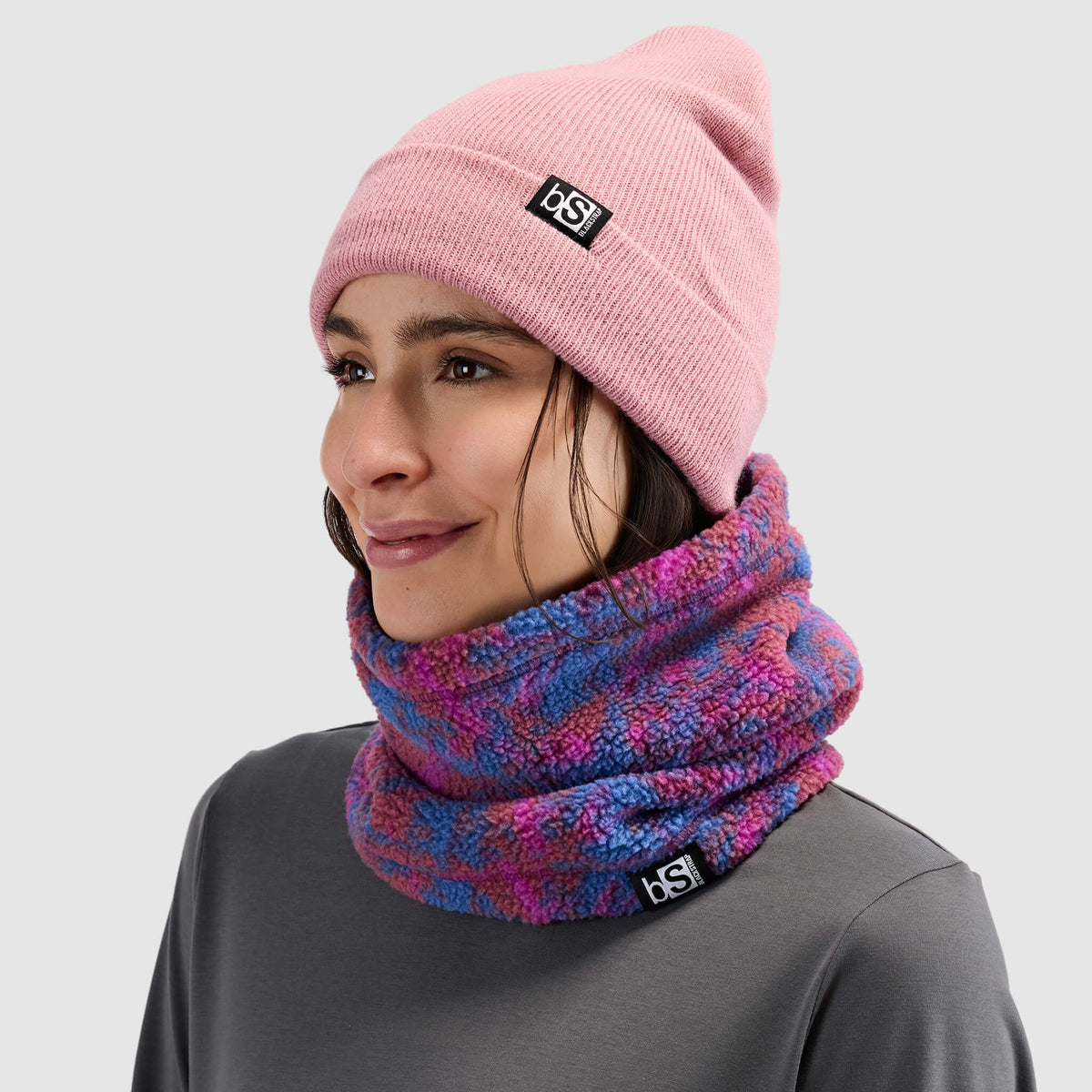 BlackStrap Caldera Sherpa Fleece Tube Neck Gaiter Pulse Currant worn by a woman with a beanie #color_pulse currant