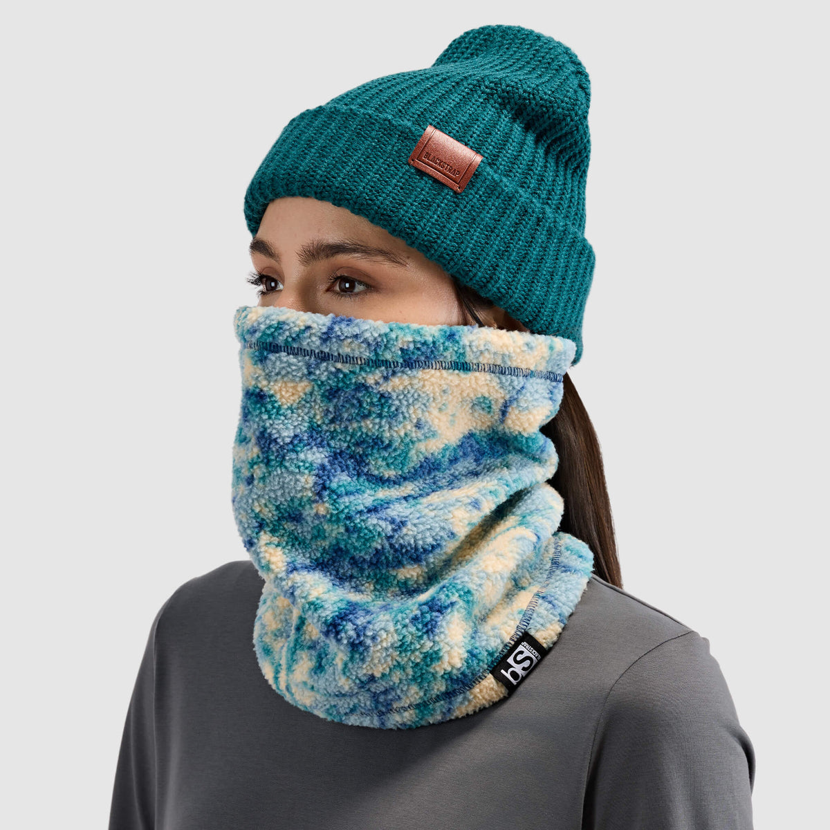 BlackStrap Caldera Sherpa Fleece Tube Neck Gaiter Pulse Deschutes worn by a woman with a beanie #color_pulse deschutes